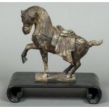 A Chinese cast metal Tang style horse Typically modelled, standing on a scrolling hardwood base.