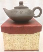 A Chinese Yixing pottery teapot and cover The body with incised decoration and calligraphic script,