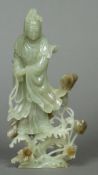A Chinese carved jade figure of Guanyin Modelled holding a string of beads standing amongst budding