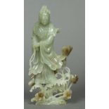 A Chinese carved jade figure of Guanyin Modelled holding a string of beads standing amongst budding