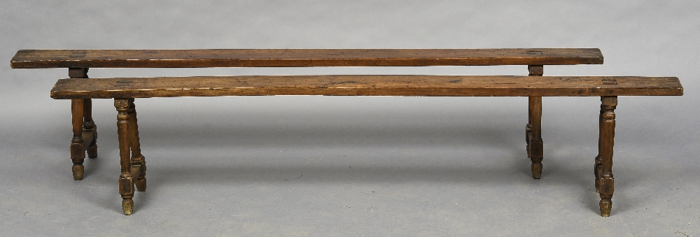 A pair of 19th century French fruitwood, probably cherry, benches Each of typical trestle form,