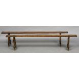 A pair of 19th century French fruitwood, probably cherry, benches Each of typical trestle form,