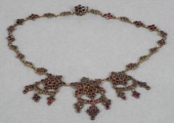 A 19th century cut garnet necklace Set with three stars each issuing three further drops.