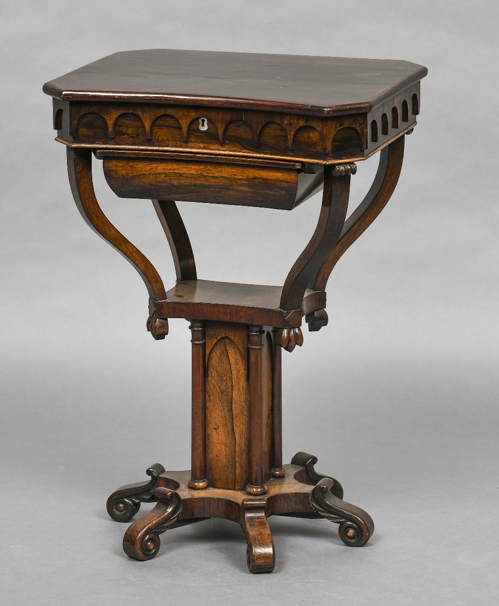 A 19th century Gothic Revival rosewood work table The shaped hinged top enclosing a fitted interior