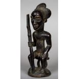 An African carved wooden tribal figure Modelled as a male seated holding a club. 28 cm high.