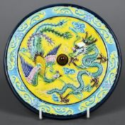 A Chinese porcelain roundel The blue and yellow ground centred with a dragon and a phoenix,