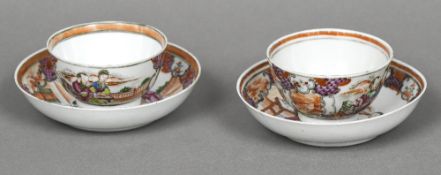 A pair of Chinese porcelain tea bowls and saucers Each decorated with figures on a terrace.