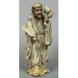 A large Chinese soapstone figure Formed as a bearded gentleman holding a fan with a double gourd