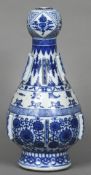 A Chinese blue and white porcelain altar vase Of baluster form with garlic head and applied flanges,