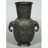 A Chinese patinated bronze vase With twin elephant mask handles,