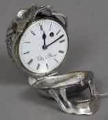 An unmarked silver desk clock Formed as a skull with pierced scrollwork and a cartouche,