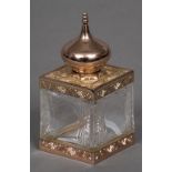 An Amouage metal mounted cut crystal scent bottle Of square section with domed removable lid.