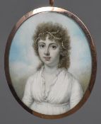 An early 19th century portrait miniature on ivory Depicting a young girl with pearls in her hair,