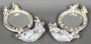 A pair of Continental porcelain mirrors together with a pair of associated Continental porcelain