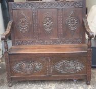 A Victorian carved oak hall settle