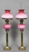 A pair of gilt metal Corinthian column and coloured glass gas lamps With coloured glass shades.