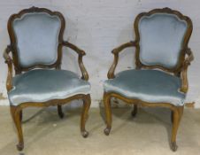 A pair of 19th century French walnut upholstered open armchairs