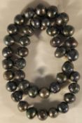 A string of black pearls with a 14 ct clasp