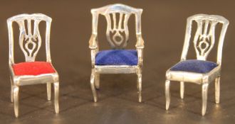 Three miniature silver chairs