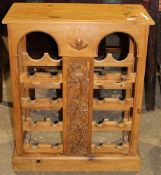 A carved pine wine rack