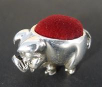 A silver pin cushion in the form of a pig