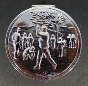 A silver pill box depicting a golfer