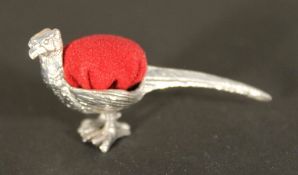 A silver pin cushion in the form of a pheasant