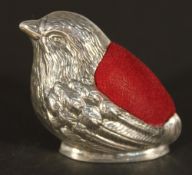 A silver pin cushion in the form of a bird