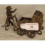 A cold painted bronze model formed as a dog pushing a pram