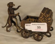 A cold painted bronze model formed as a dog pushing a pram