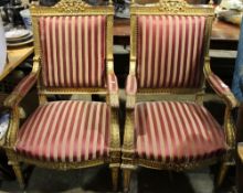 A pair of red upholstered gilt wood open armchairs