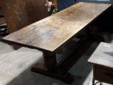 A large oak refectory table The rectangular plank top above twin turned supports,