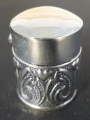 A small silver round embossed box