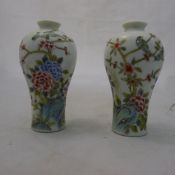 A pair of small vases decorated with birds and flowers