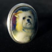 A silver and enamel ring depicting a dog