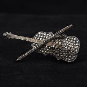 A silver marcasite set brooch Formed as a violin and bow. 5 cm wide.