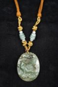 A Chinese carved jade pendant Carved with a mythical beast beneath a bat,