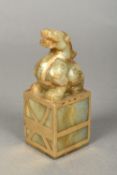 A Chinese carved russet jade and gilt decorated seal Surmounted with a mythical beast,