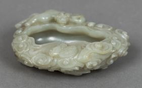 A Chinese carved jade brush washer Carved as stylised clouds surmounted with a mythical beast