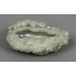 A Chinese carved jade brush washer Carved as stylised clouds surmounted with a mythical beast