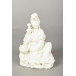 A Chinese blanc de chine porcelain group Worked as a seated Guanyin holding a sword next to a