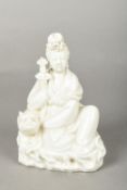 A Chinese blanc de chine porcelain group Worked as a seated Guanyin holding a sword next to a