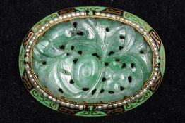 An enamel decorated and seed pearl mounted 14K gold and jade brooch The central pierced jade panel