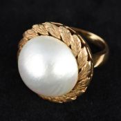 A large pearl mounted gold ring Of domed circular form,