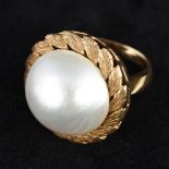 A large pearl mounted gold ring Of domed circular form,