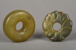 Two Chinese carved jade roundels Each centrally pierced. The largest 5.25 cm diameter.