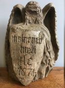 A 17th century carved oak memento mori Worked as an angel holding a shield inscribed Memento Mori