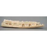 An ivory group Carved as figures aboard a traditional boat. 23 cm long.