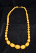 A butterscotch amber bead necklace The oval beads of graduated size. 55 cm long.