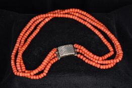 A three strand coral necklace Set with an unmarked silver clasp. 42.5 cm long.
